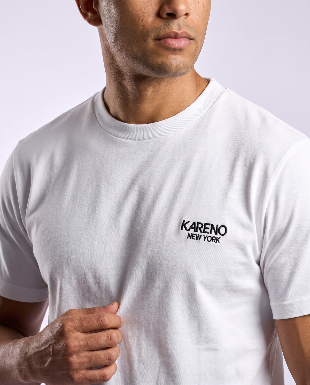 Borough Emblem Crew Tee in White, close-up of the chest emblem on a model